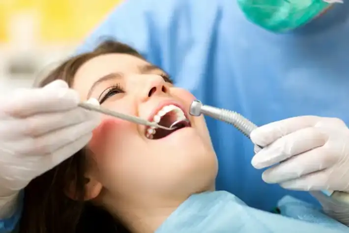 A woman receiving dental treatment with professional tools.