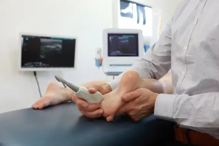 A doctor performs an ultrasound on a baby's foot.