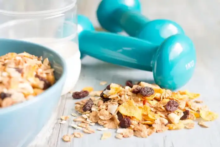 Healthy breakfast with granola and teal dumbbells.