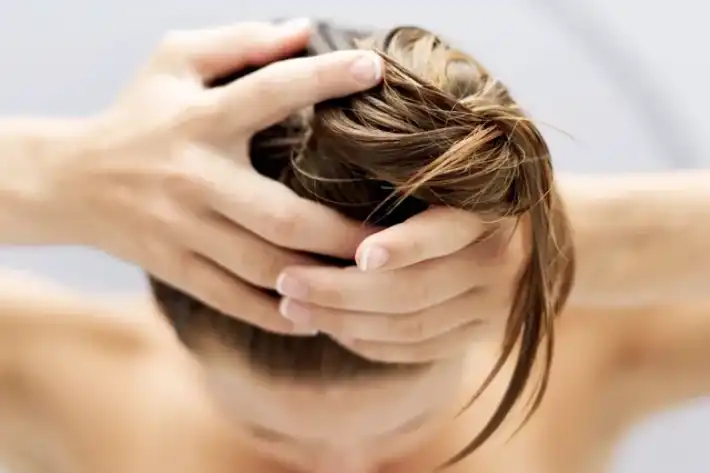 Person holding their hair tightly in a stressed manner.