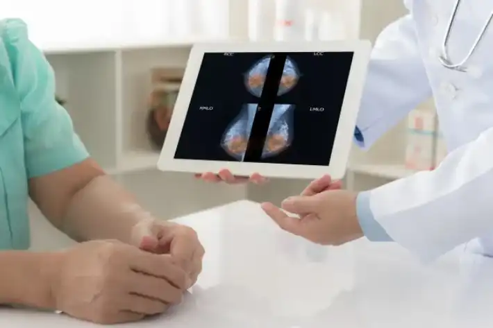 Doctor showing lung X-rays on a tablet to a patient.