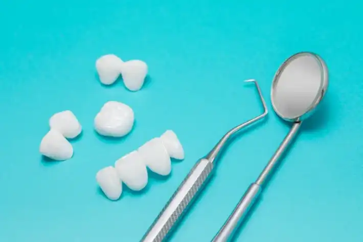 Dental tools and model teeth on a blue background.