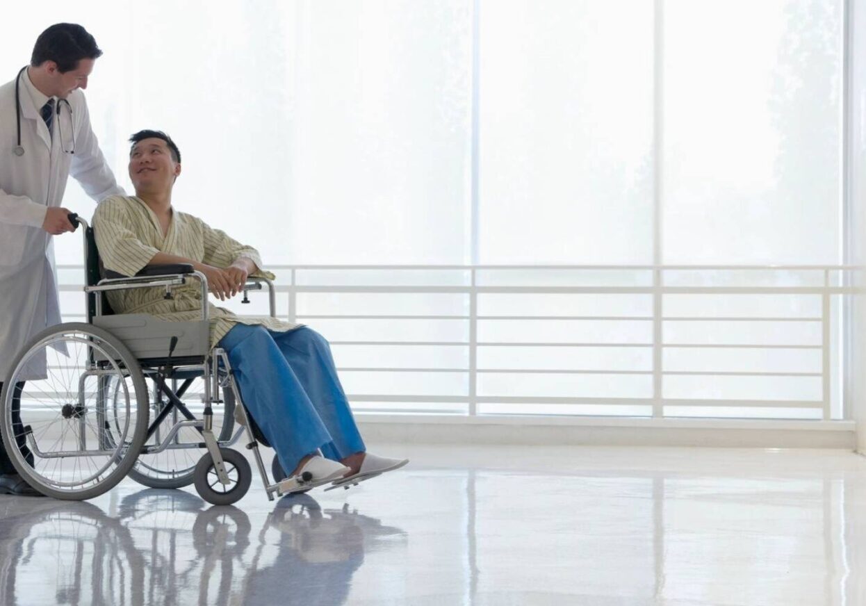 A patient comfortably rides a mobility scooter indoors.